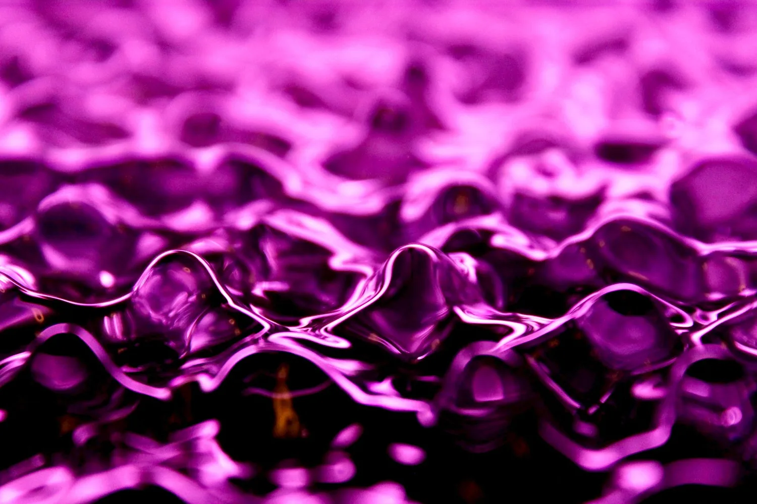 Textura líquida abstracta en tonos violeta con reflejos luminosos y profundidad.